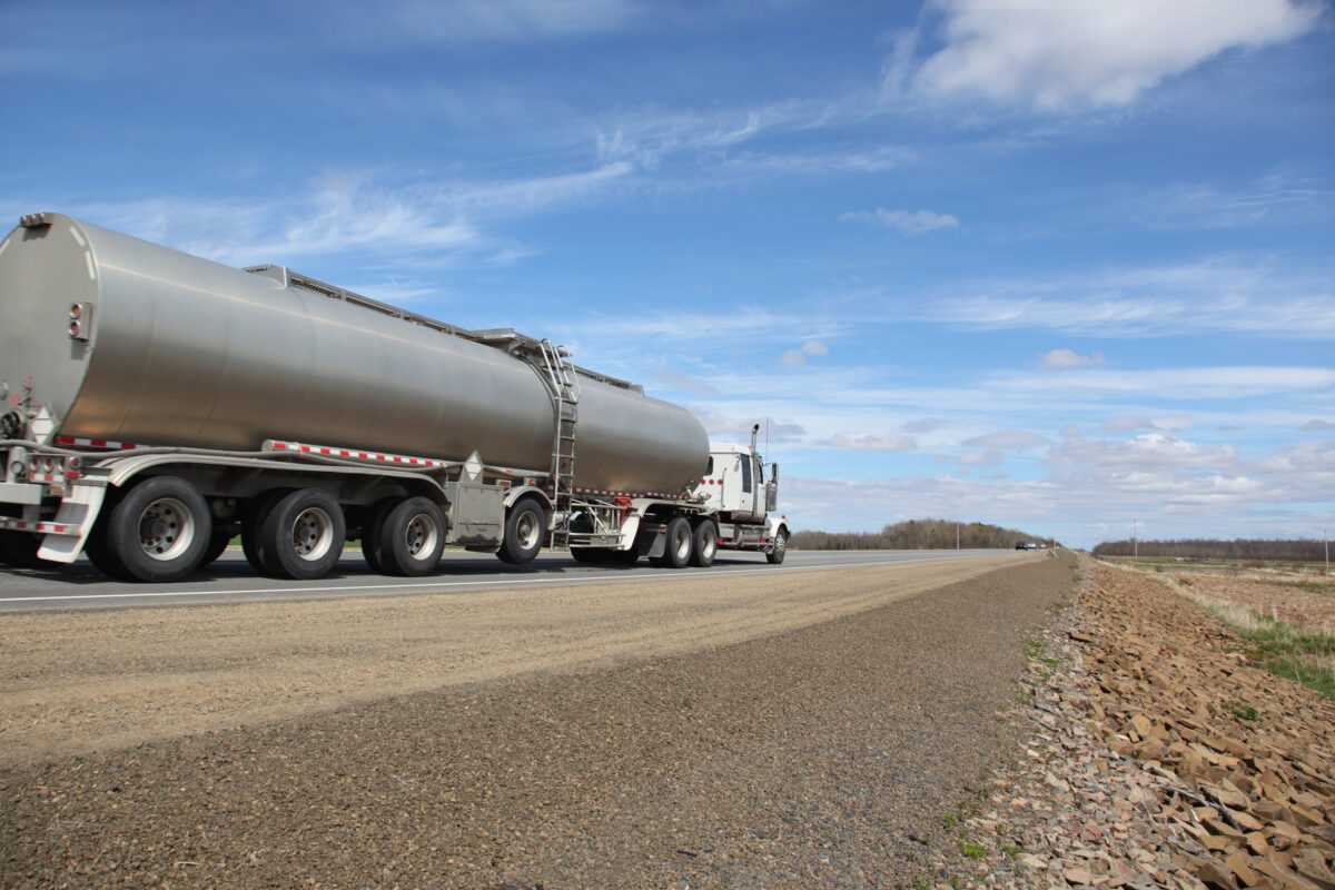 Truck tanking delivering its load. Selective focus on front of truck. Rear of trailer out of focus. Motion blur of tires and perhaps some on rear of truck.For similar pictures go to