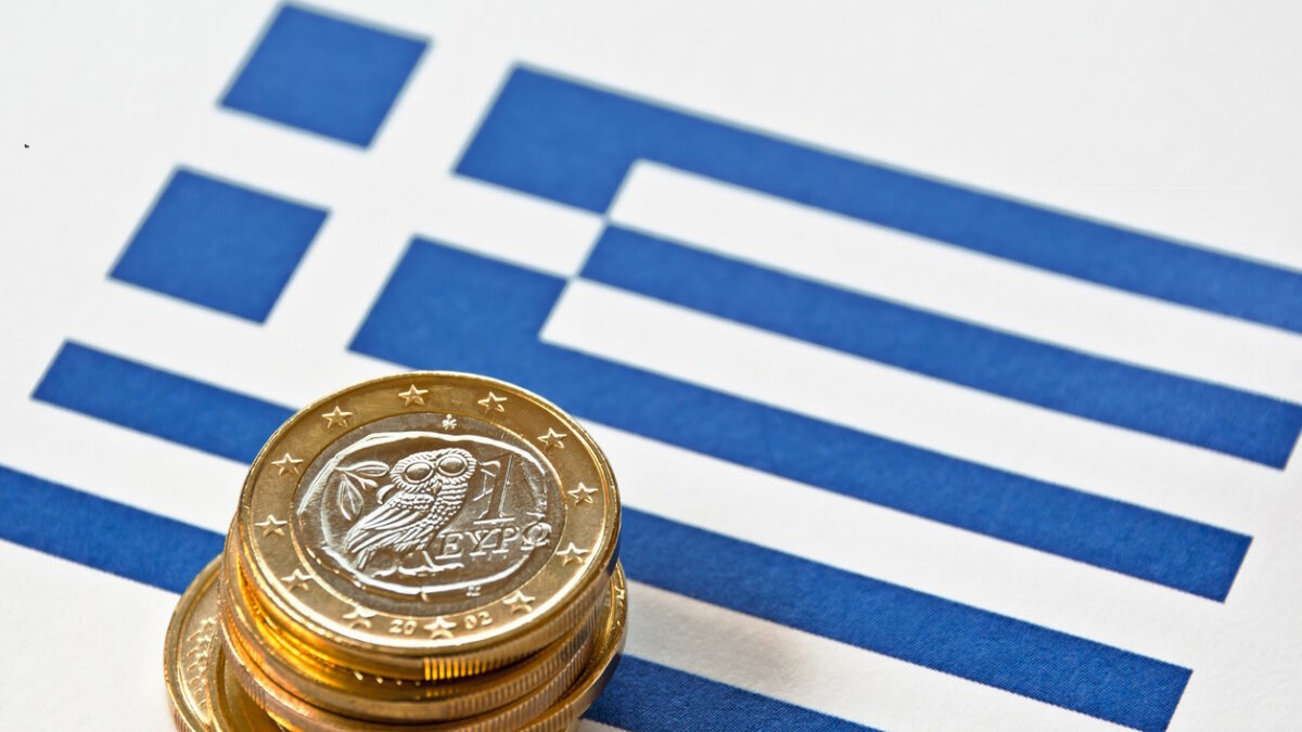 Close-up of a Greek flag and Greek euro coins. Focus is on the Greek euro.Similar images: