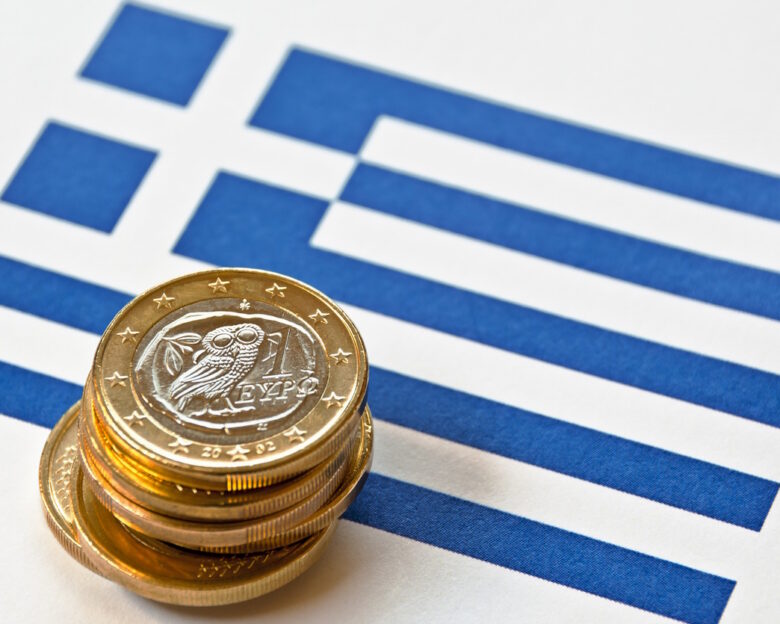 Close-up of a Greek flag and Greek euro coins. Focus is on the Greek euro.Similar images: