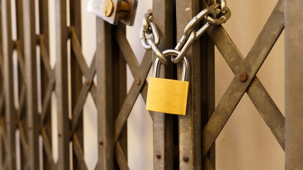 metal door of a business closed with a padlock due to the crisis