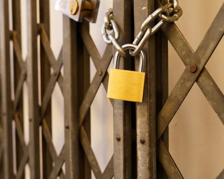 metal door of a business closed with a padlock due to the crisis