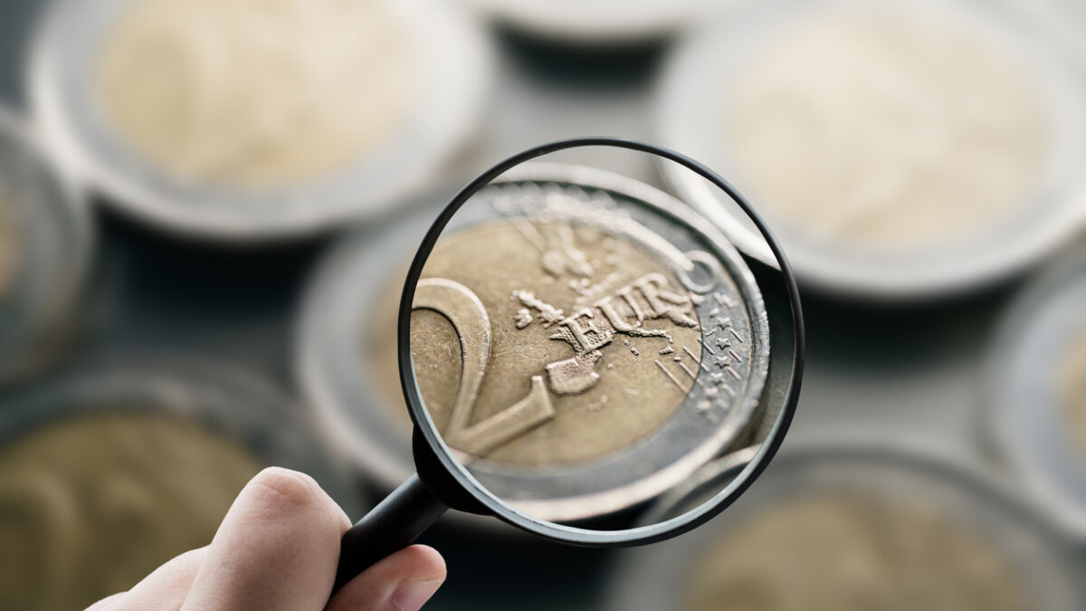 A magnifying glass focusing on 2 euro coins