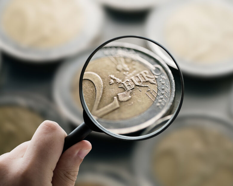 A magnifying glass focusing on 2 euro coins