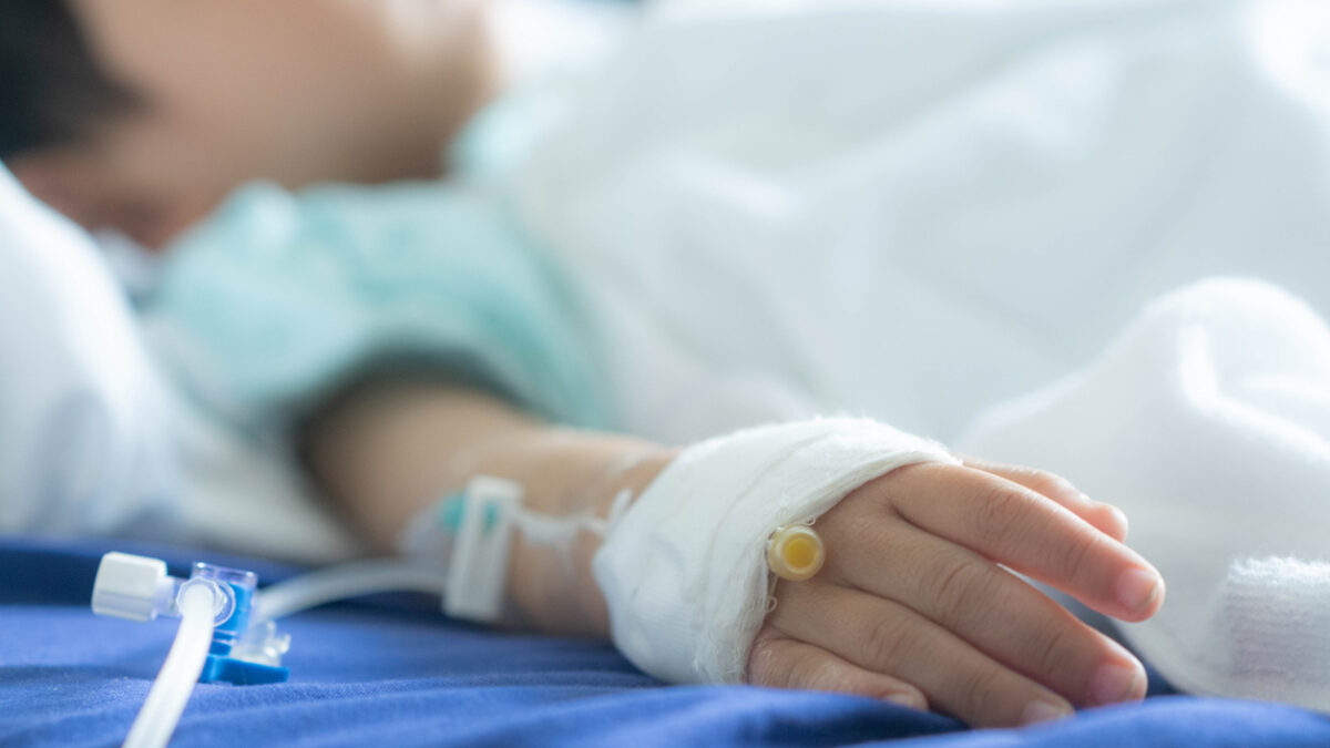 an Asian todler in hospital with intravenous saline. Sick children, infected with the virus, are lying and being treated in beds in hospitals.