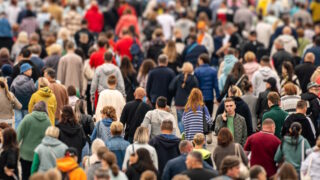 A young man is talking on the phone surrounded by a crowd during rush hour in a large metropolis. Russia, Barnaul. August 31, 2024.