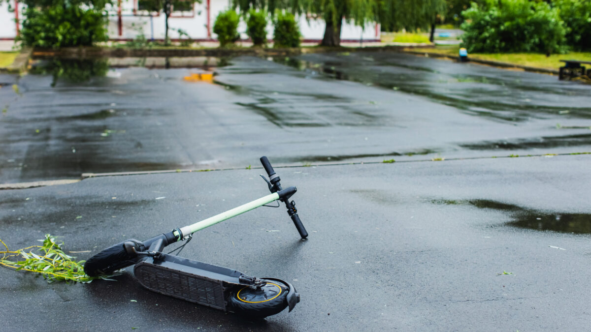 Electric scooter fallen on road. Storm in city
