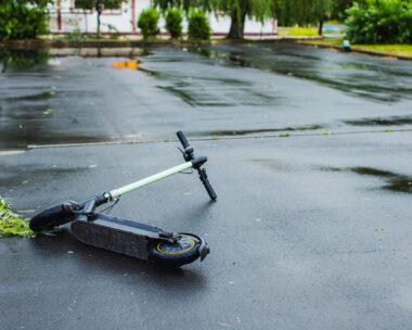Electric scooter fallen on road. Storm in city