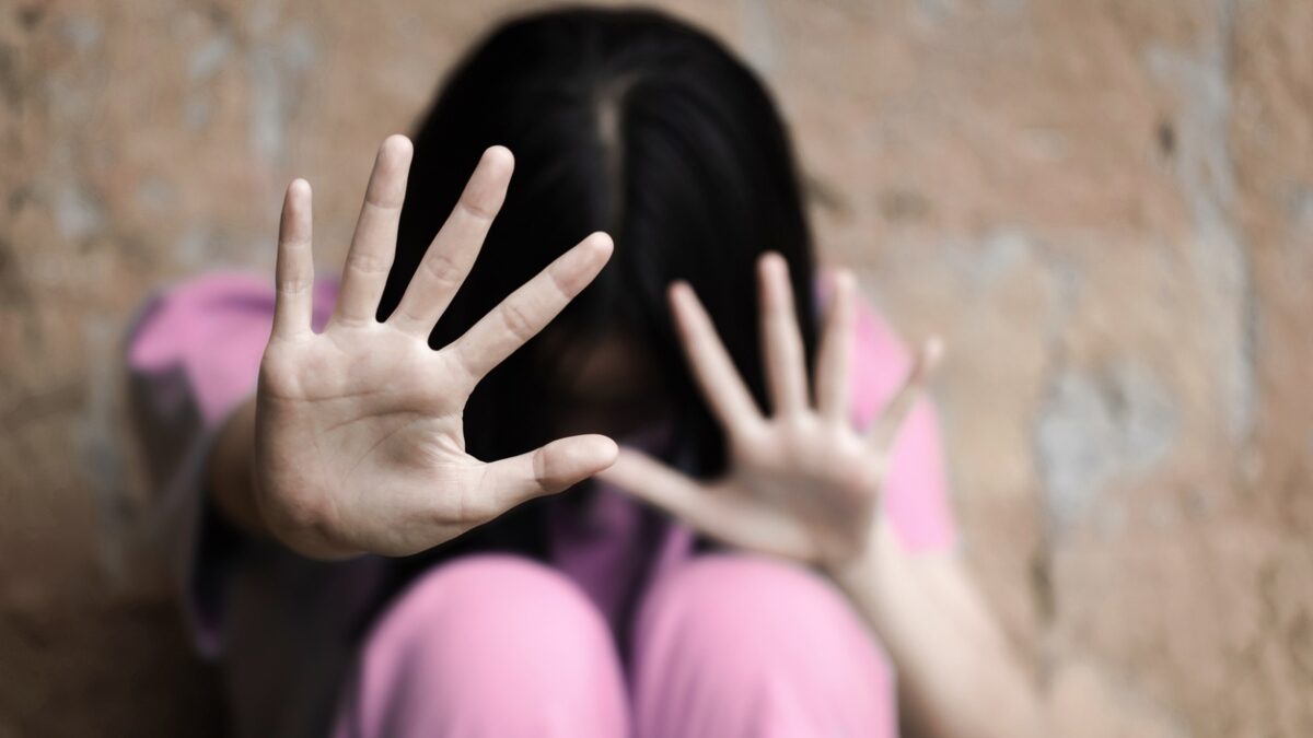 A woman raising her hands to stop violence against women and trafficking children. Abuse concept.