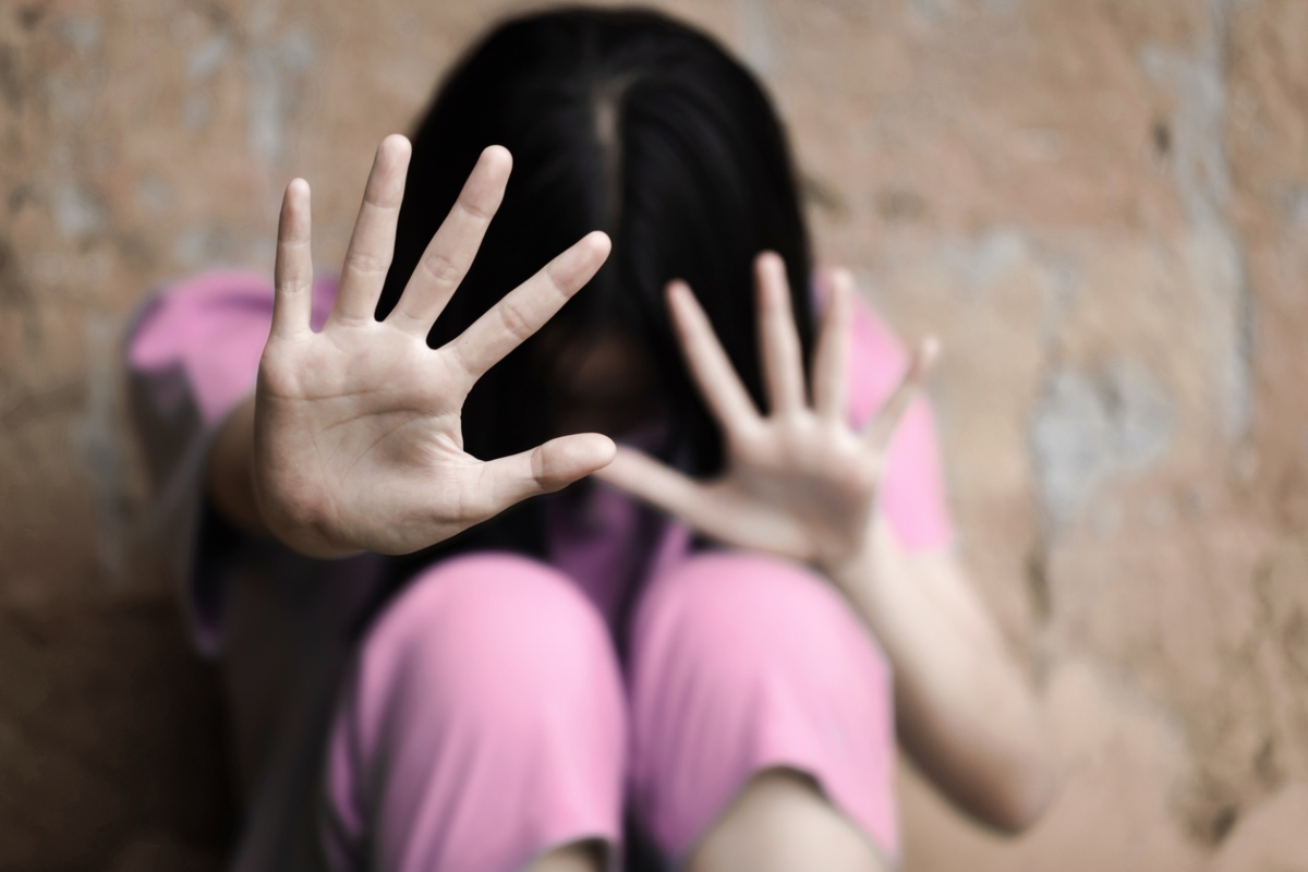 A woman raising her hands to stop violence against women and trafficking children. Abuse concept.