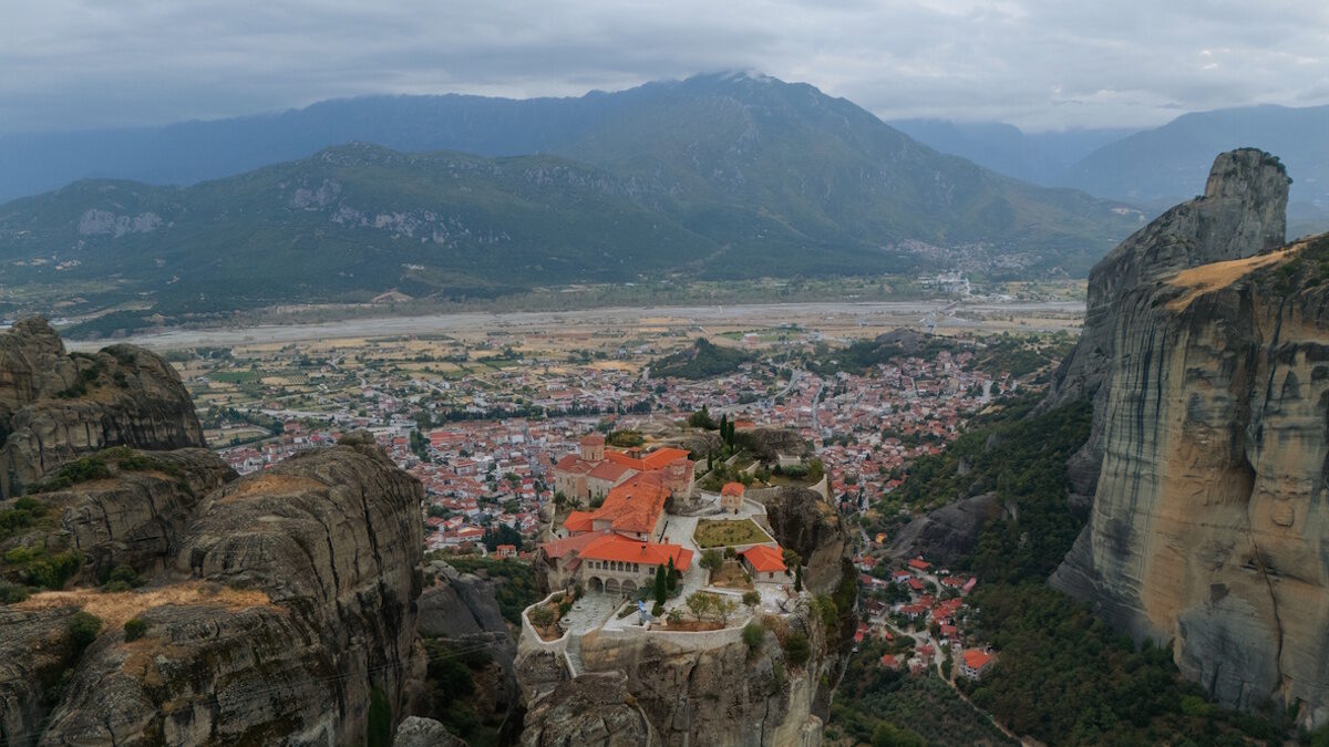 Holy Trinity Monastery perched on a towering rock formation overlooking the valley and Kastraki village in Meteora, Greece