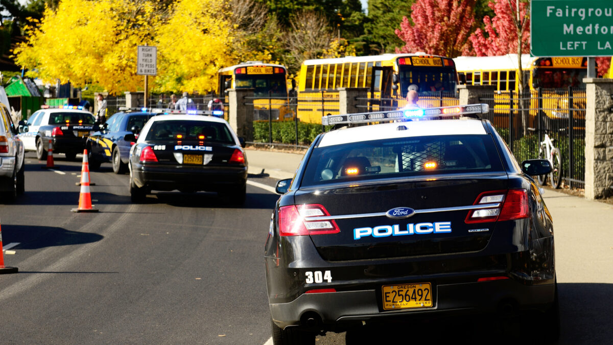 Roseburg Oregon - October 16, 2012: Police cars and school buses at an accident scene at the entrance of the High School loading zone