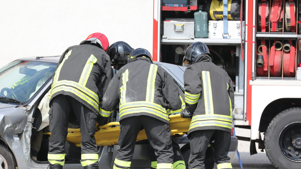 team of firefighters pulling the from the bumpy car after the traffic accident on the highway CommentFC