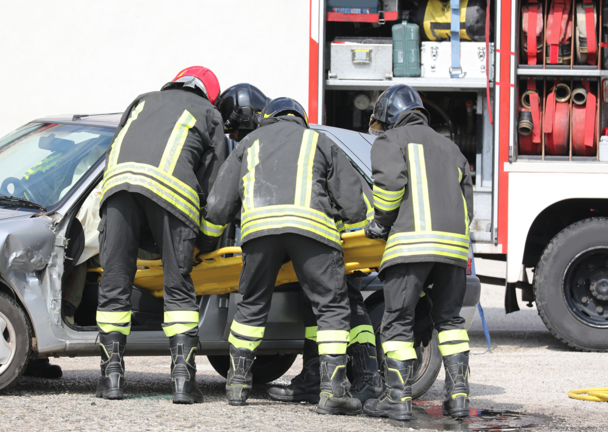 team of firefighters pulling the from the bumpy car after the traffic accident on the highway CommentFC