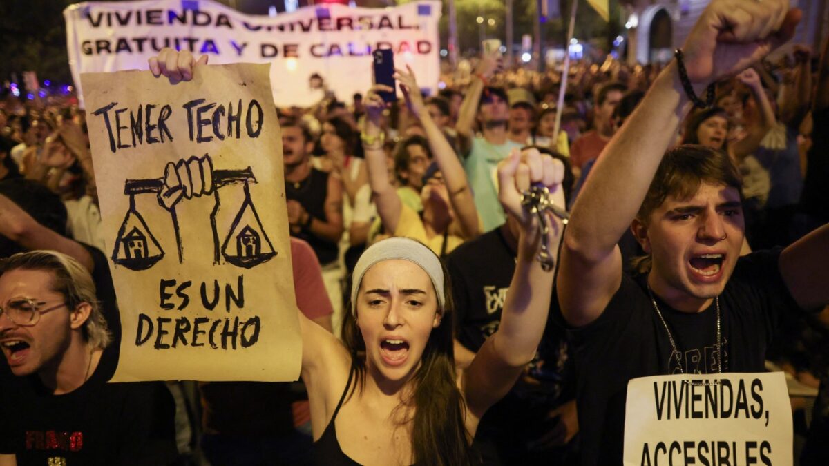 Διαδηλωτές κρατούν πλακάτ που γράφουν «Η στέγαση είναι δικαίωμα» και «Οικονομικά προσιτή στέγαση» κατά τη διάρκεια διαμαρτυρίας για τη στεγαστική κρίση στην Ισπανία