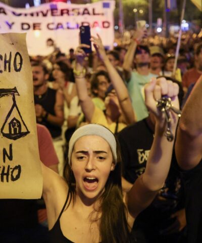 Διαδηλωτές κρατούν πλακάτ που γράφουν «Η στέγαση είναι δικαίωμα» και «Οικονομικά προσιτή στέγαση» κατά τη διάρκεια διαμαρτυρίας για τη στεγαστική κρίση στην Ισπανία