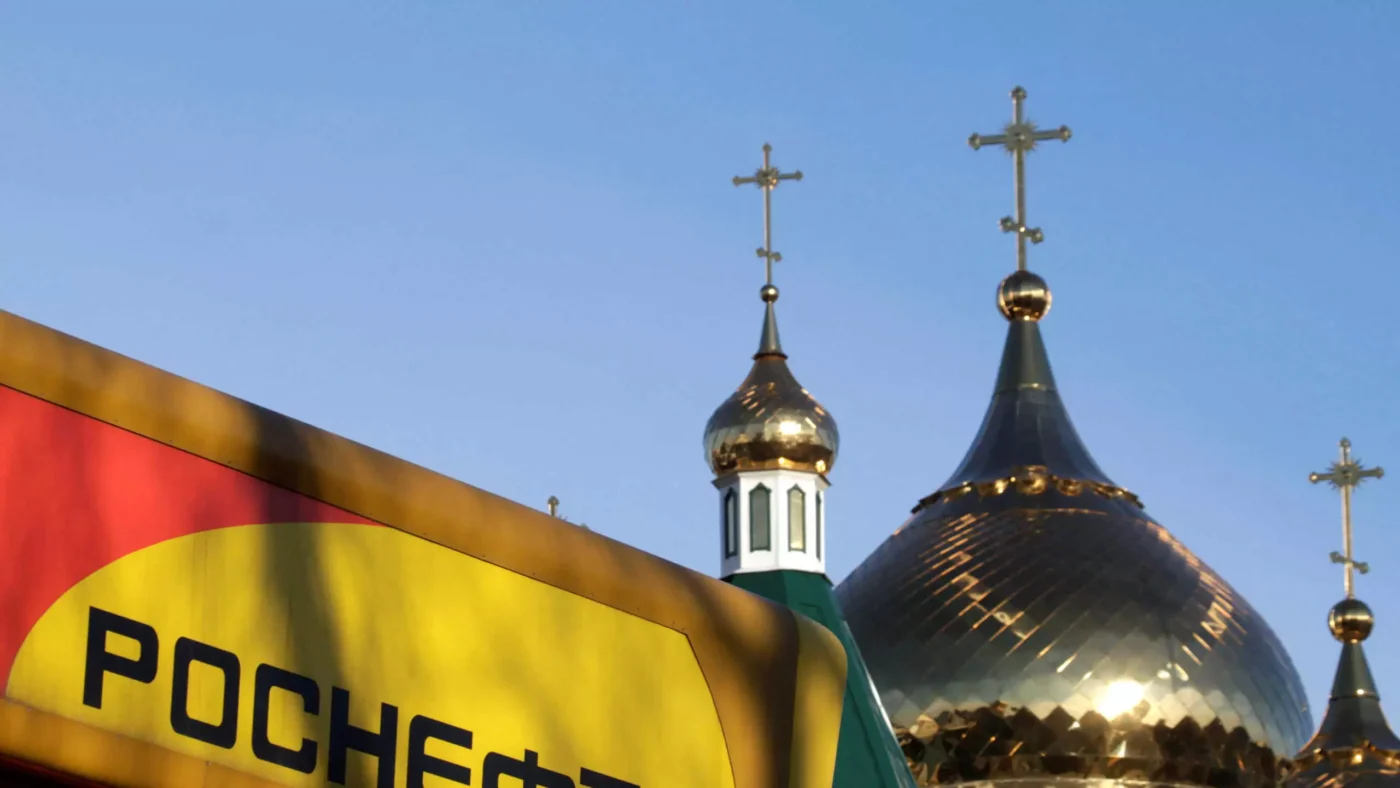 FILE PHOTO: The logo of Russia's top crude producer Rosneft is seen on a gasoline station near a church in Stavropol, southern Russia, December 9, 2014.