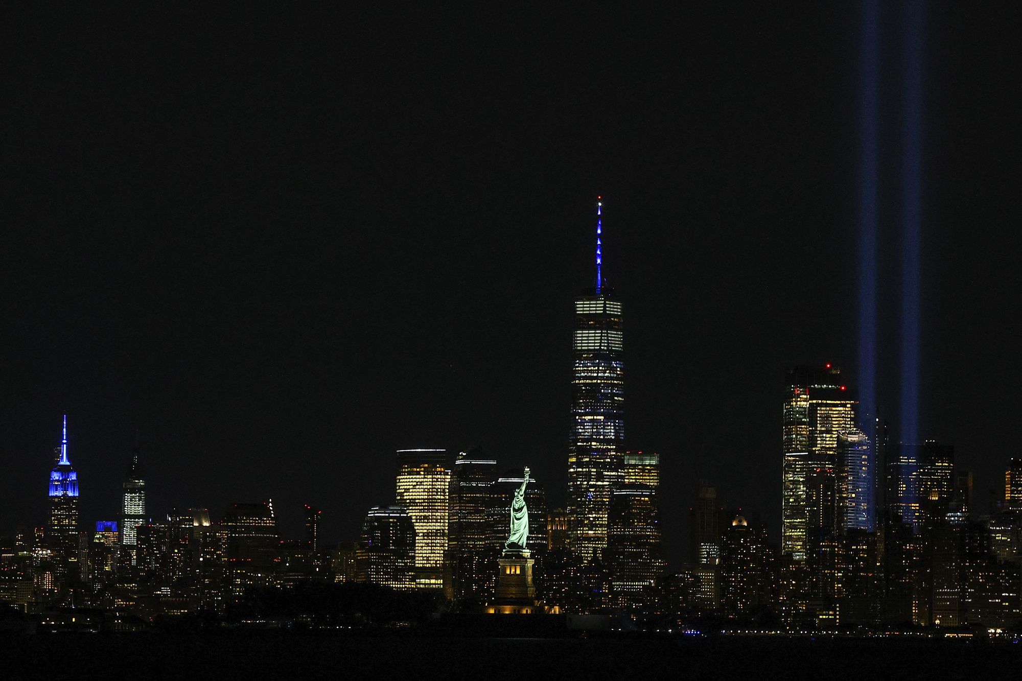Γενική άποψη των «Δίδυμων Πύργων του Φωτός» (Twin Towers of Light), στη 19η επέτειο της επίθεσης στο Παγκόσμιο Κέντρο Εμπορίου. Οι δέσμες φωτός υψώνονται προς τον ουρανό, με το Άγαλμα της Ελευθερίας, το Freedom Tower και το Empire State Building να διακρίνονται γύρω τους