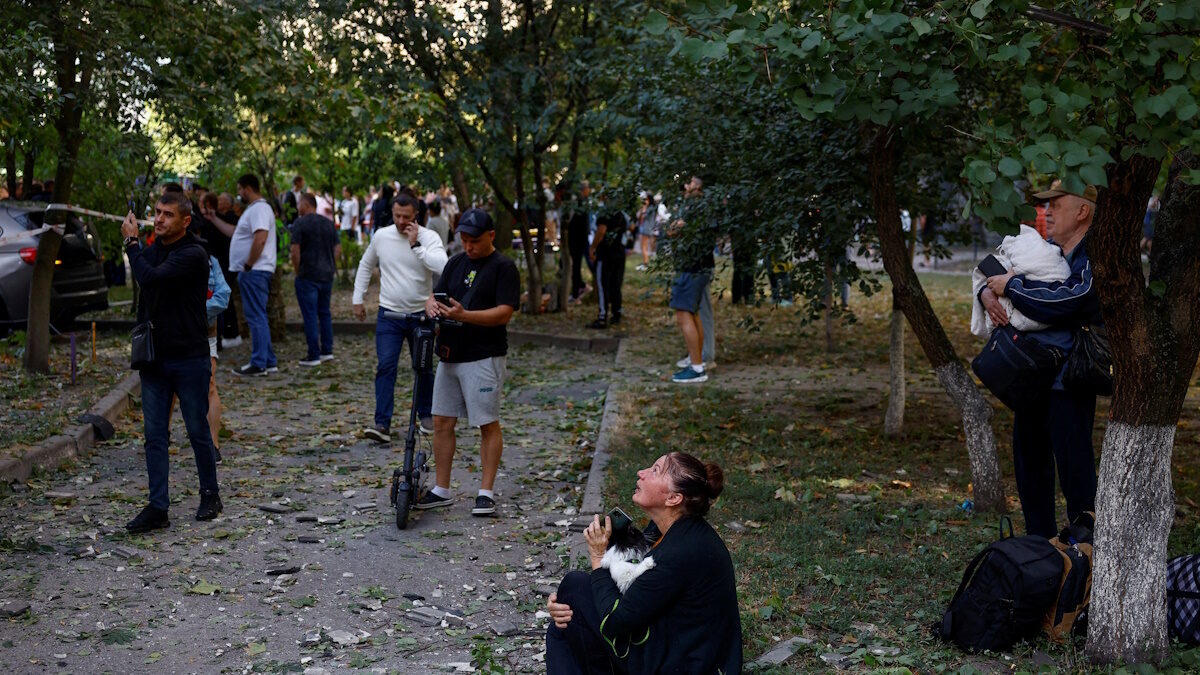 Μια γυναίκα κοιτάζει την πολυκατοικία της που έχει πληγεί από επίθεση ρωσικού drone, στο πλαίσιο της ρωσικής επίθεσης κατά της Ουκρανίας, στο Κίεβο