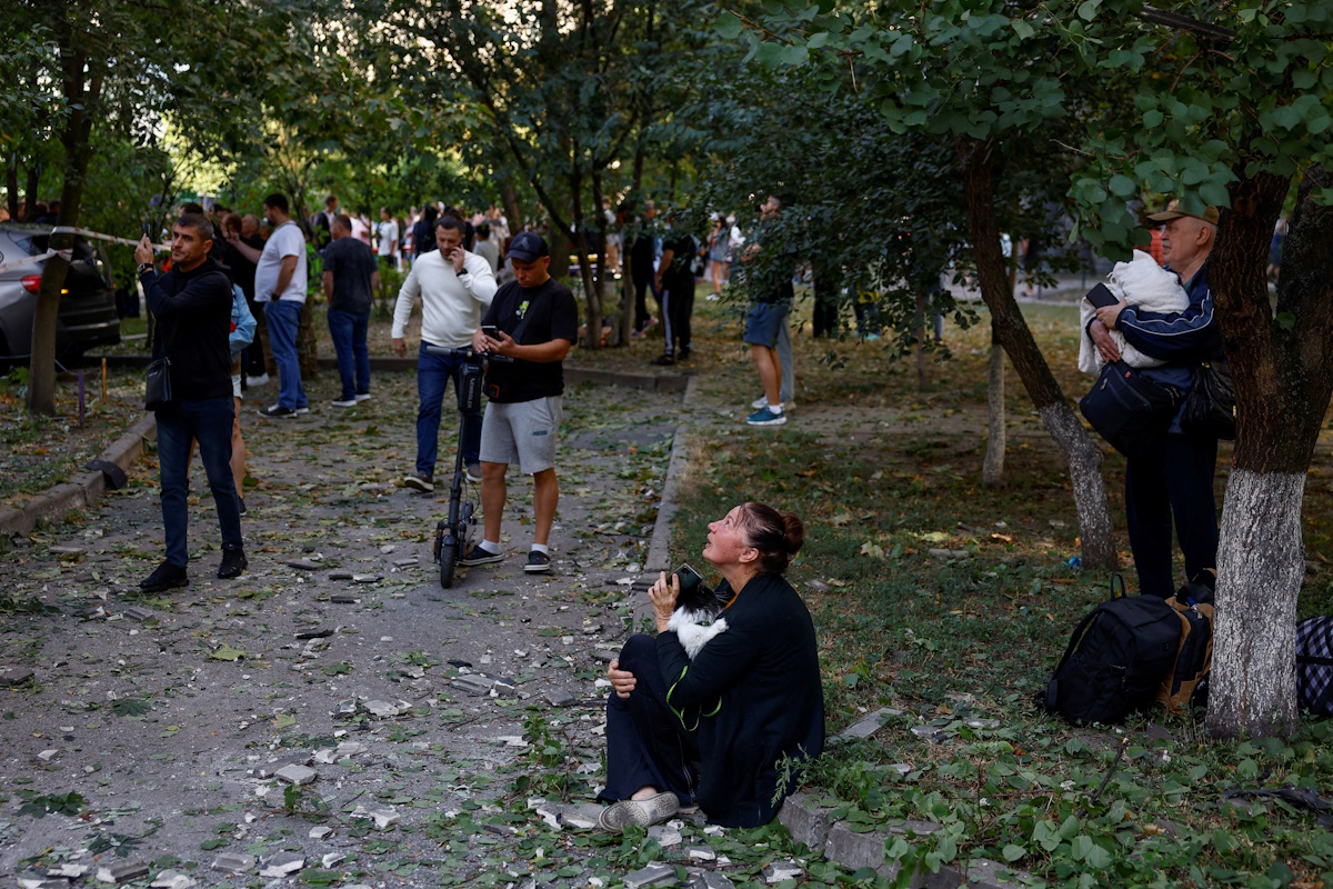 Μια γυναίκα κοιτάζει την πολυκατοικία της που έχει πληγεί από επίθεση ρωσικού drone, στο πλαίσιο της ρωσικής επίθεσης κατά της Ουκρανίας, στο Κίεβο