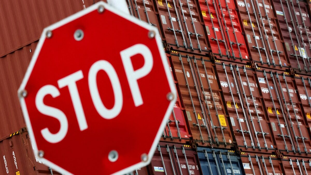 FILE PHOTO: A stop sign is pictured in front of shipping containers at the Port of Long Beach in Long Beach, California, U.S., July 11, 2025.