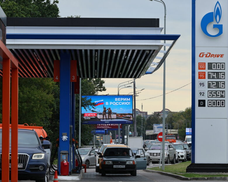 Cars queue to refuel at a Gazprom Neft fuel station amid fuel shortages following recent series of Ukrainian air attacks on oil refineries in Russian regions and further gasoline production cuts, in the course of the Russia-Ukraine conflict, in Moscow, Russia, August 20, 2026. The banner marking the upcoming National Flag Day reads: "We believe in Russia!" REUTERS