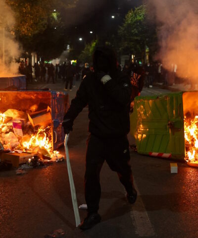 Διαδηλωτής ανάμεσα σε πυρπολημένους κάδους στη διάρκεια αντικυβερνητικής διαδήλωσης στα Τίρανα στις 17 Οκτωβρίου 2026