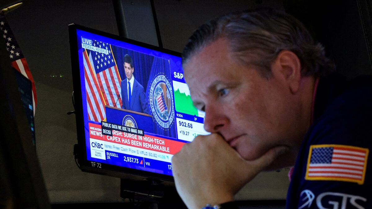 FILE PHOTO: A trader works, as a screen broadcasts a press conference by US Federal Reserve Chair Kevin Warsh following the Fed rate announcement, on the floor of the New York Stock Exchange (NYSE) in New York City, US, July 29, 2026.
