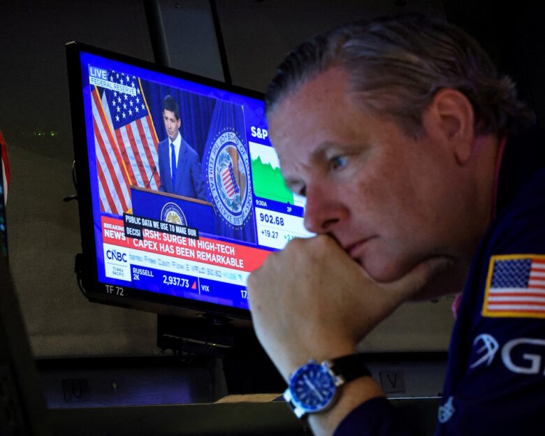 FILE PHOTO: A trader works, as a screen broadcasts a press conference by US Federal Reserve Chair Kevin Warsh following the Fed rate announcement, on the floor of the New York Stock Exchange (NYSE) in New York City, US, July 29, 2026.