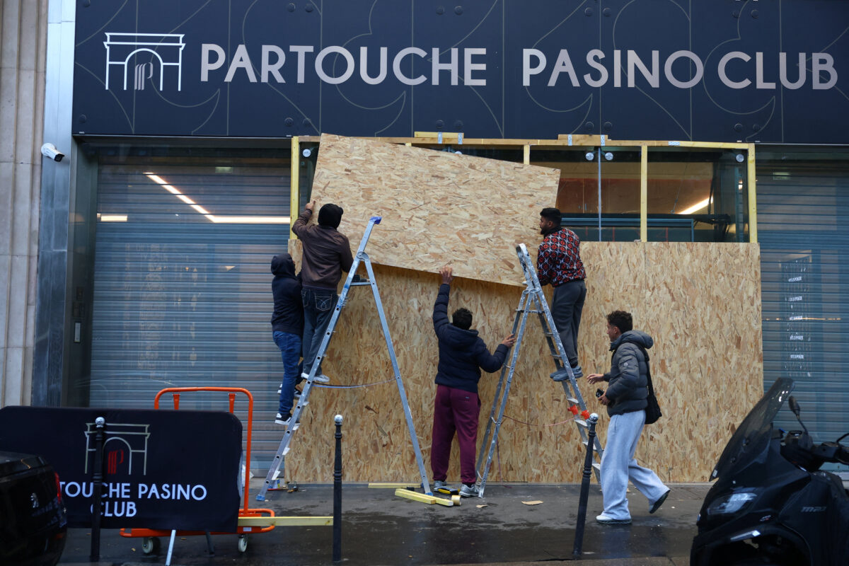 Workers install wooden panels to protect the windows of the gaming club Partouche Pasino Club in Paris ahead of nationwide protests called by the "Yellow Vests" movement joined by French high school and university students, against the cost of living and rising fuel prices in France, October 24, 2026. REUTERS