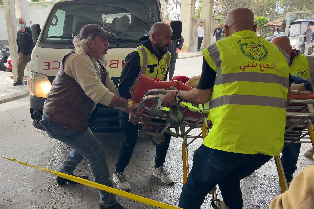 Rescue workers carry an injured man to a hospital emergency entrance after an Israeli airstrike hit a crowded neighborhood in southern Beirut, Sunday, April 5, 2026.