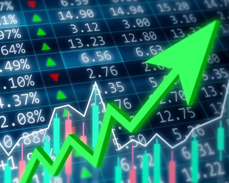 Stock market, financial and business concept. Financial data on a monitor with green arrow going up and red, green candle stick graph chart on dark background