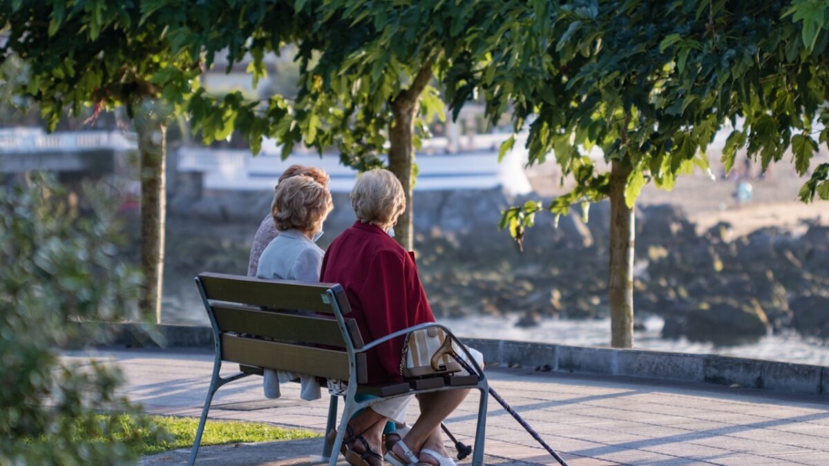 Castro Urdiales, Cantabria, Spain - September 04, 2021: Senior women in the park relax at sunset on the coast of the Bay of Biscay.