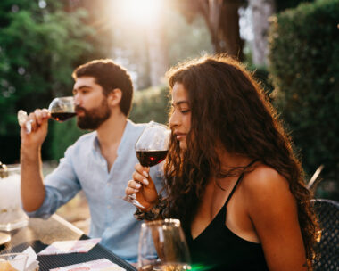 People are having a wine tasting experience at the farmhouse. Sunset time. Friends on vacation together.