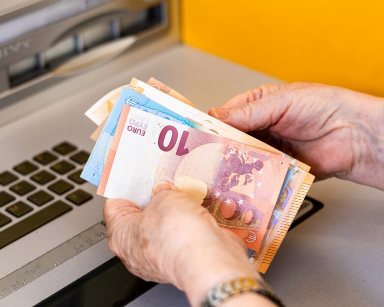 Close-up, woman's hands counting euro bills at the ATM