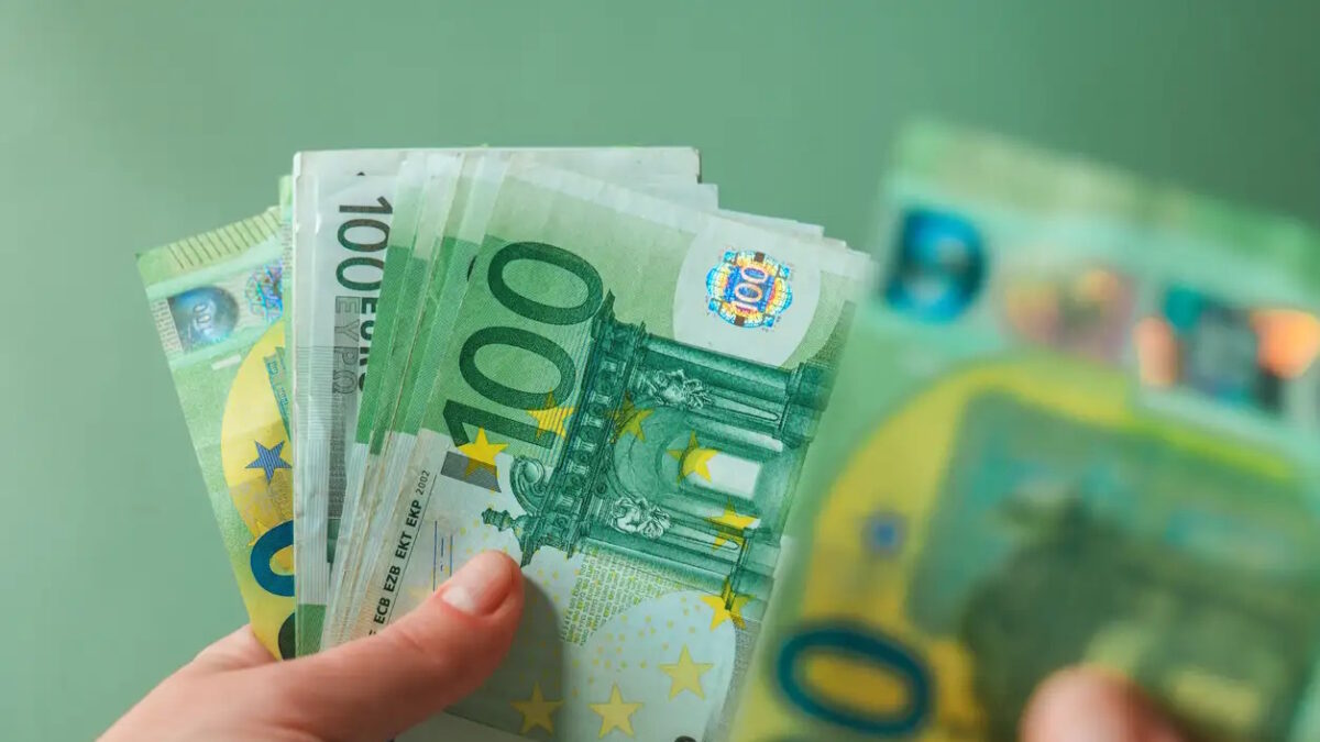 salary of a woman. euro banknotes in hands on a green background. Income of women in European countries