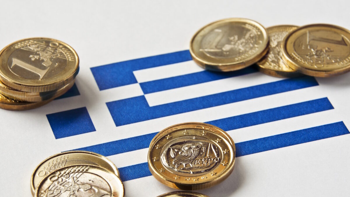 Close-up of a Greek flag and Greek euro coins. Focus is on the Greek euro.Similar images: