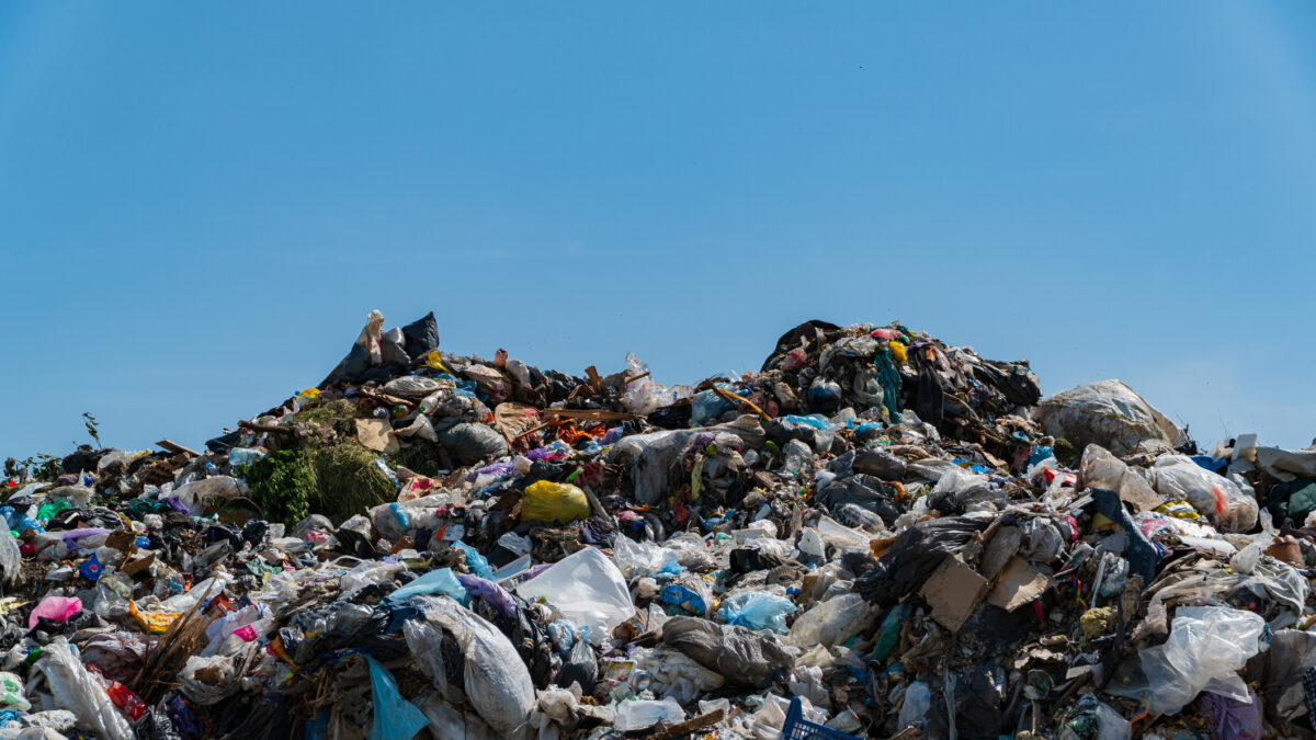 A massive landfill filled with heaps of plastic debris and garbage, showcasing the urgent need for effective waste management and recycling solutions.