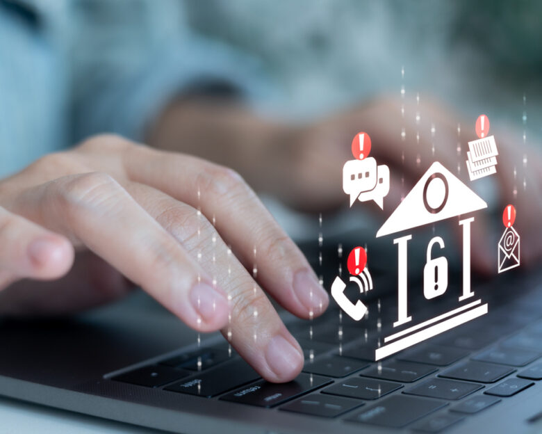 Hands typing on a laptop with banking and alert icons, symbolizing online banking security, digital finance protection, cyber fraud alert, fintech risk management, and financial data safety.