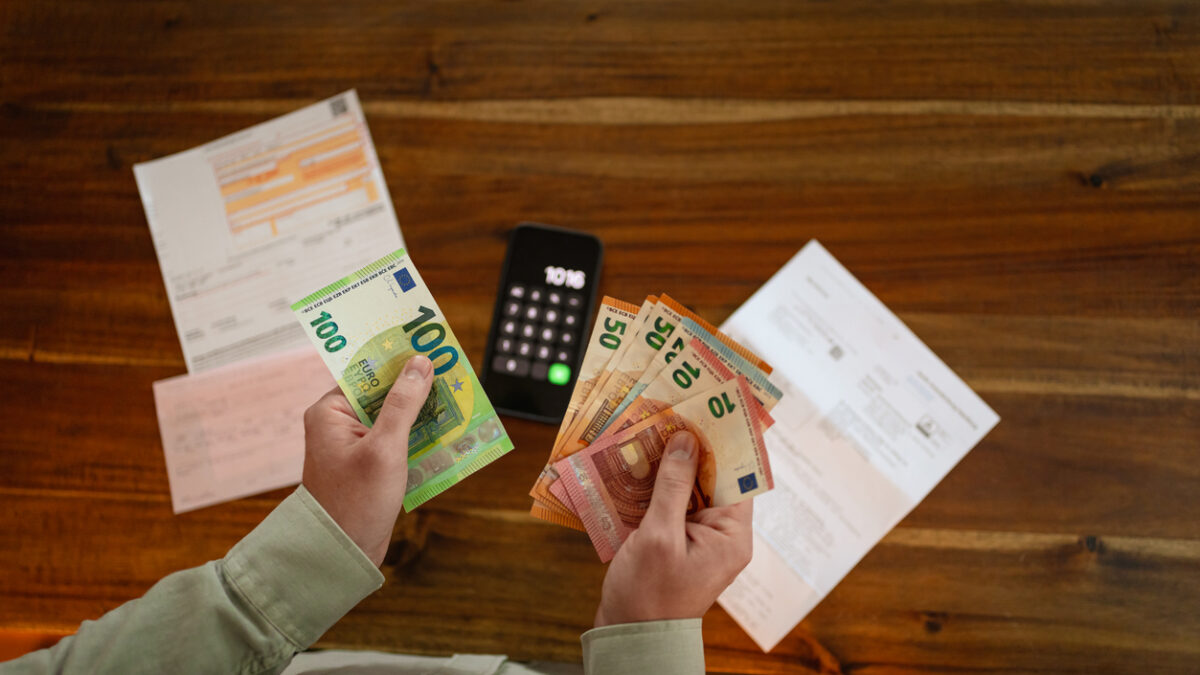 Close up of hands counting euro banknotes while planning household expenses and reviewing financial obligations