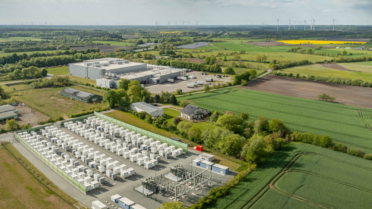 Grid-scale battery storage and substation in a commercial and industrial area surrounded by rural energy landscape. Large-scale battery energy storage system (BESS). installation.
