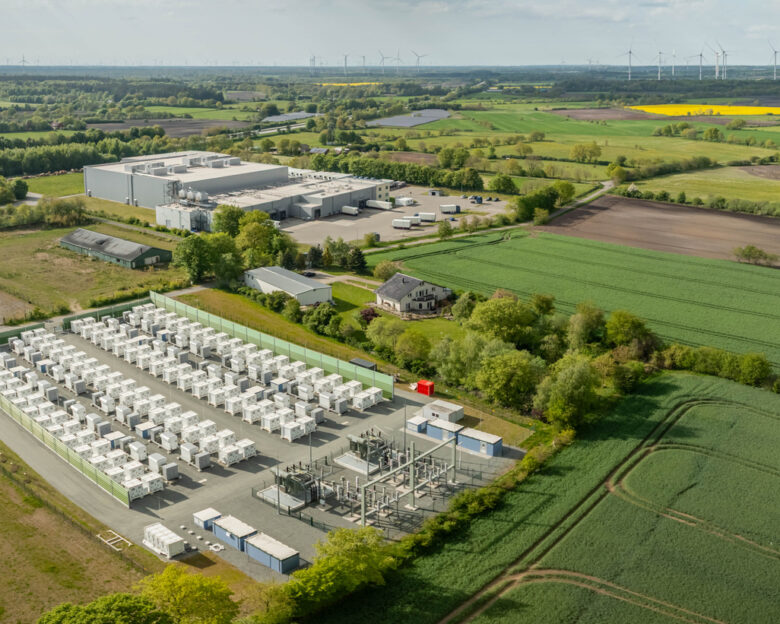 Grid-scale battery storage and substation in a commercial and industrial area surrounded by rural energy landscape. Large-scale battery energy storage system (BESS). installation.
