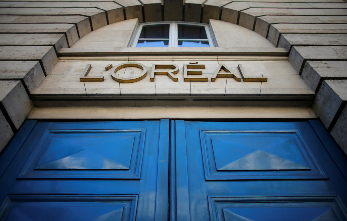 FILE PHOTO - A logo is seen over the entrance of Cosmetics company L'Oreal building in Paris, August 16, 2013. REUTERS/Christian Hartmann/File Photo GLOBAL BUSINESS WEEK AHEAD PACKAGE - SEARCH 'BUSINESS WEEK AHEAD 6 FEB' FOR ALL IMAGES