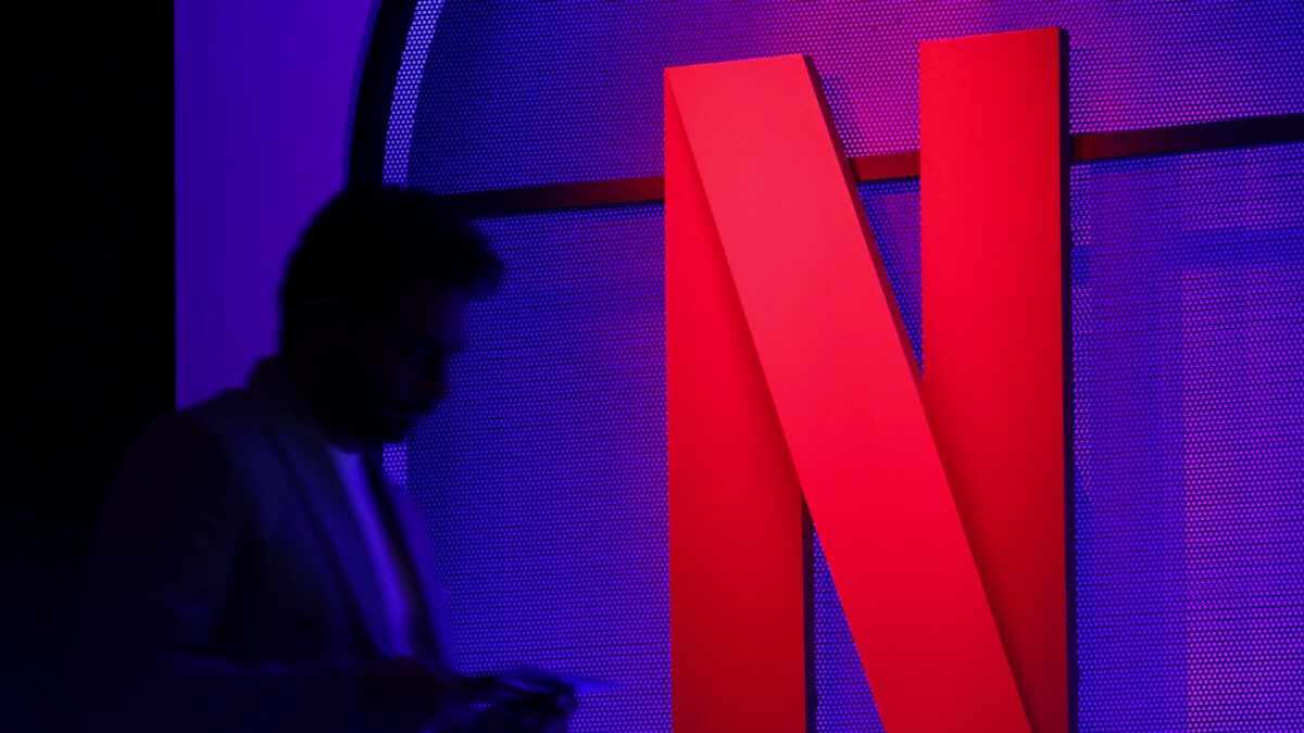 FILE PHOTO: A man stands next to a logo of Netflix during an event in Mumbai, India, February 29, 2024.