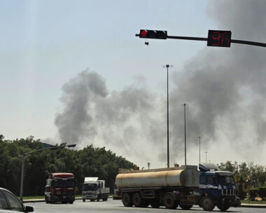 Vehicles travel along a road as black smoke billows from a fire at an oil facility in an industrial area in southern Riyadh, Saudi Arabia, Saturday, Oct. 3, 2026. (AP Photo)