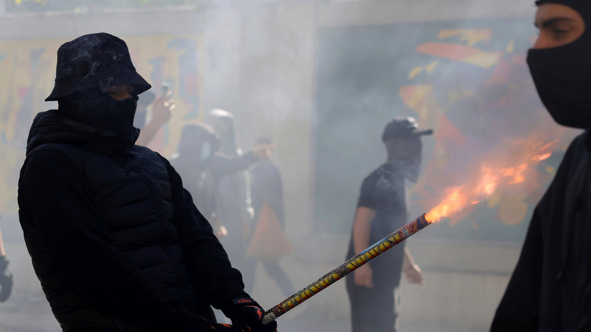 A protester uses a firework against police during clashes in Tirana, Albania, Wednesday, Oct. 14, 2026, joining a demonstration organized by the Flamingo protest movement demanding the resignation of Prime Minister Edi Rama.
