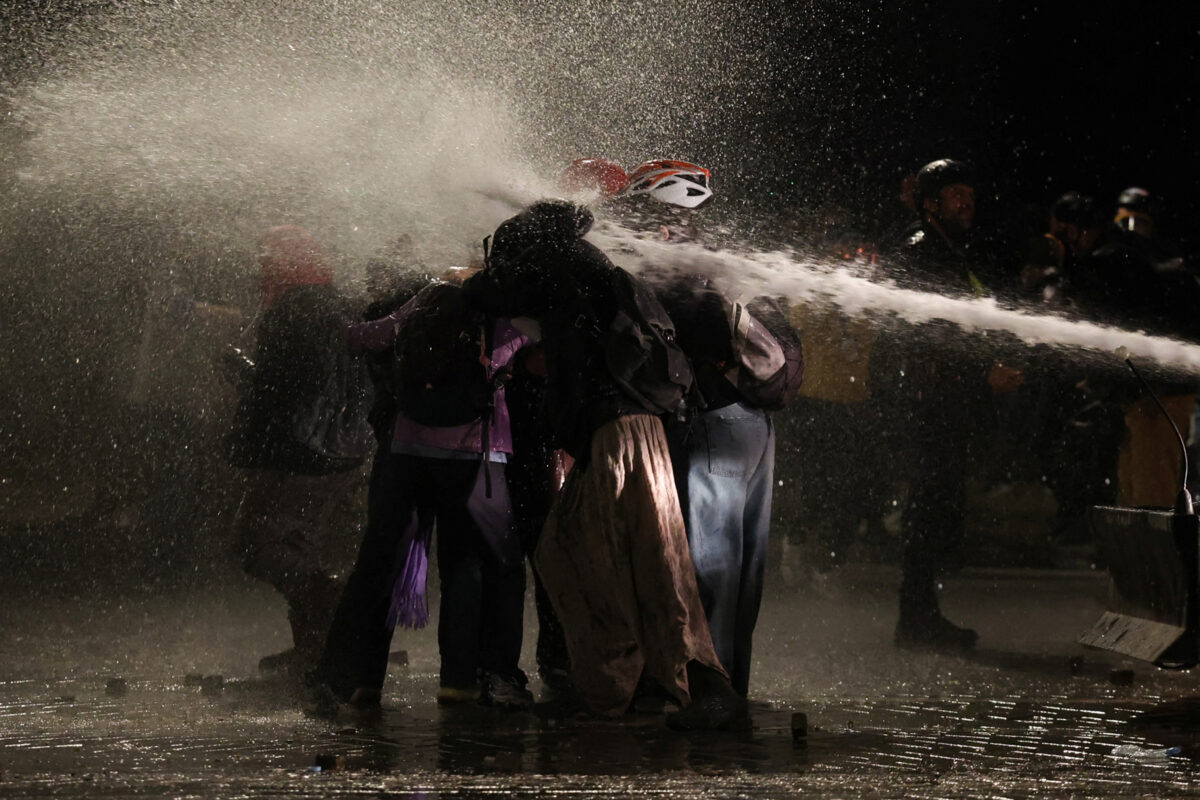 Protesters react amid water sprayed from a water cannon, after trying to block police advance, during an anti-government protest by students in Tirana, Albania, October 20, 2026. REUTERS