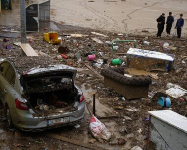 Local residents stand next to scattered vehicles and debris in the aftermath of floods caused by heavy rains, in Istanbul, Turkey, Thursday, Oct. 15, 2026.
