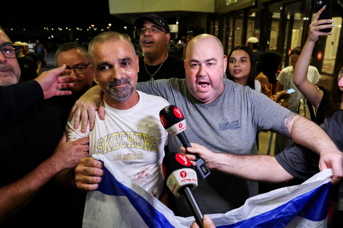 Yaniv Hayun, one of the men who helped incapacitate the attacker on the FlyDubai aircraft bound for Israel from the United Arab Emirates, which was diverted to Saudi Arabia following an emergency signal, holds an Israeli flag after arriving at the Ben Gurion International Airport, in Lod, near Tel Aviv, Israel, September 30, 2026. REUTERS